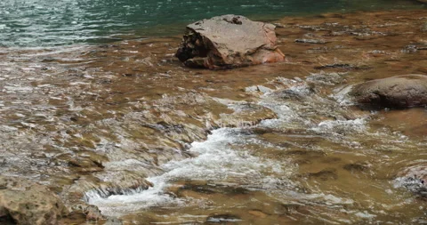 Water running Through mossy rocks Stockbeeldmateriaal 335374818