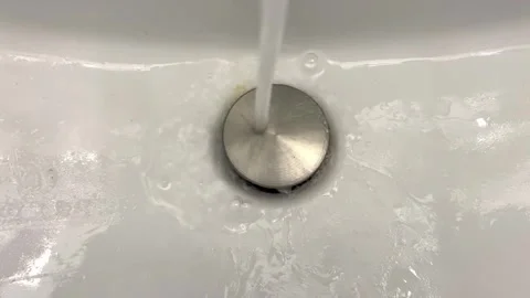 Water Running Into White Sink Drain Overhead View Video stock 344610587