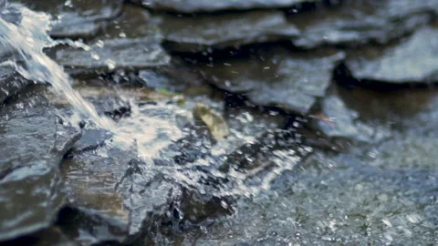 Water rushing over dark wet rocks in nature Stock Footage 336467698