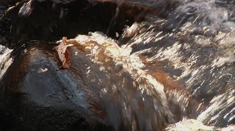 Water rushing over a rock Stock Footage 8984558