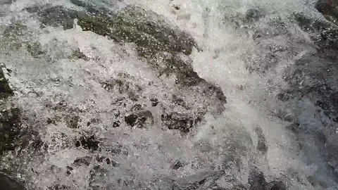 Water rushing on a river bed between river rock, 120fps 1080p Stock Footage 161691549