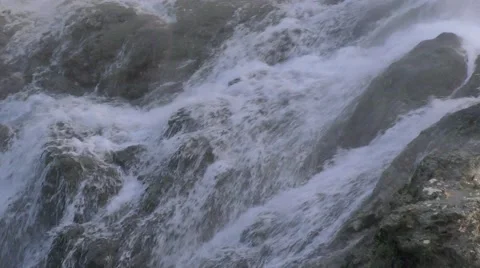 Water Rushing through Rocks at the Bottom of a Waterfall Stock Footage 68995601