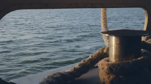 Water from a sailing ship through a deck post with cables. focus on the sea Stock Footage 118131011