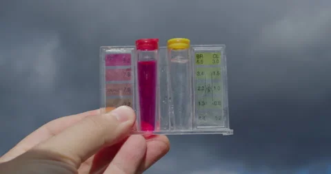 Water samples for PH and chlorine levels. Hand holding against the sky - Stock Footage 259189676