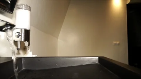 Water saving concept. Water flows from a chrome steel bathroom tap. Close up 스톡 동영상 109085013