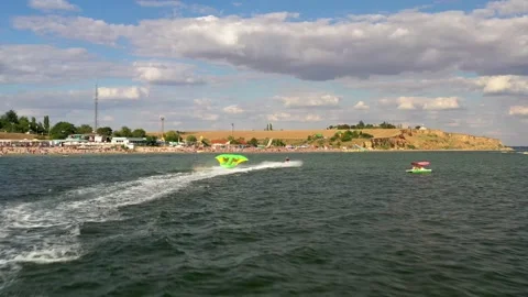A water scooter pulls people on an inflatable mattress across the sea. Stock Footage 137234225