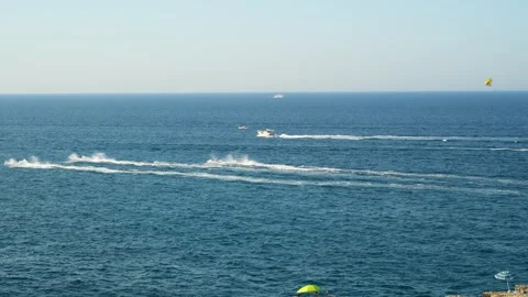 Water scooters racing across deep blue sea leave long white spray trails near 스톡 동영상 346098536