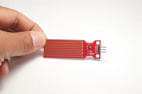 A water sensor or red rain sensor is held in a hand which is used as a DIY ma Stock Photos