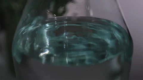 Water shaking inside glass carafe during earthquake simulation macro Video stock 344877185