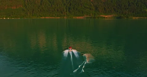 Water skiing dude pulled by the speedboat in the outdoors at blue lake with many Stock Footage 301391330