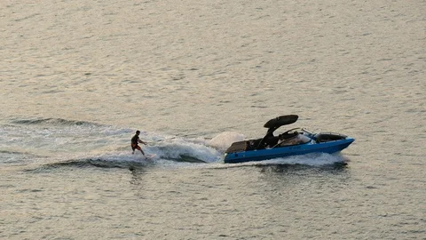 Water skiing on the sunset sea surface Video stock 119758529
