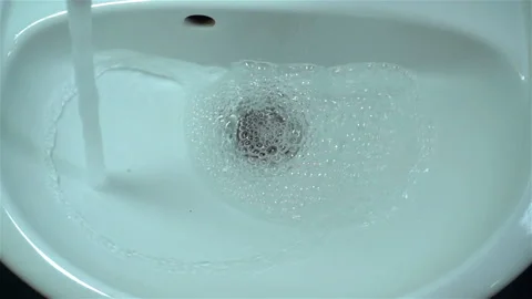 Water in slow motion flows into a sink Stock Footage 129219123