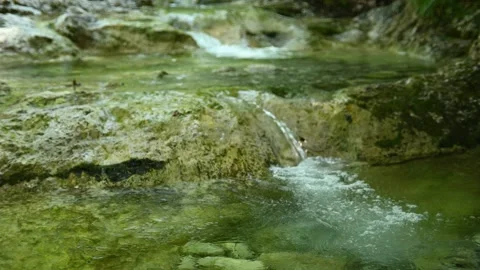 Water from a small mountain stream flows over stones Stock-Footage 211470843