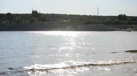 Water with small waves and far bank with knolls and forest Stock Footage 53574489