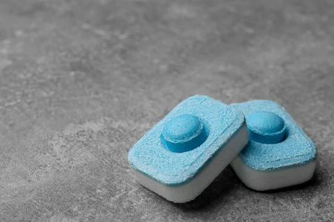Water softener tablets on grey table, closeup. Space for text Stockfoto's