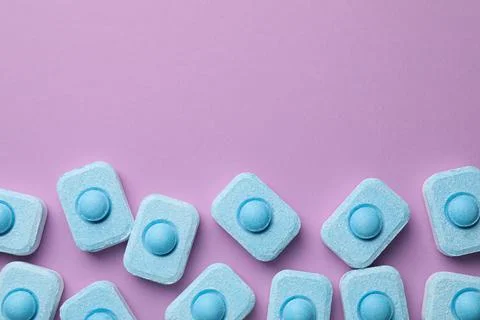 Water softener tablets on violet background, flat lay. Space for text 스톡 사진
