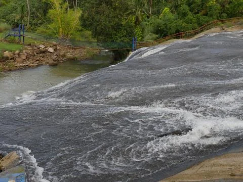 Water softly cascades down a sloping surface at the lower tier of Talafofo .. Stock Photos