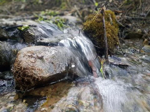 The water source flows down the rocks into the river Stock Photos