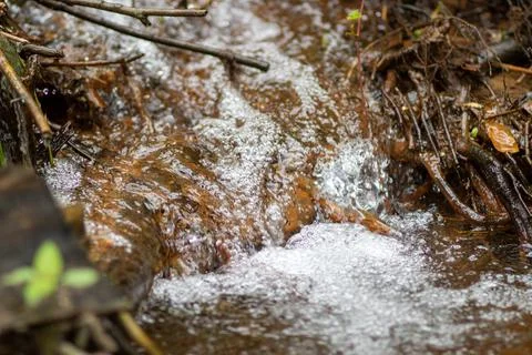 The water source flows down the rocks into the river Stock Photos