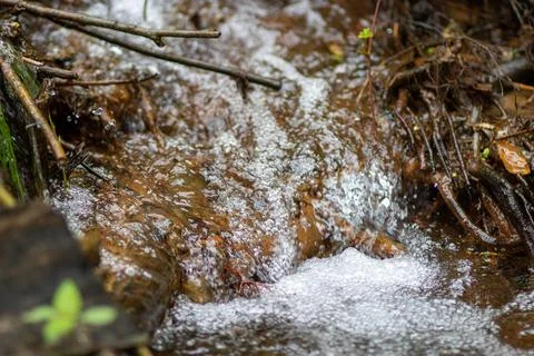 The water source flows down the rocks into the river Stock Photos