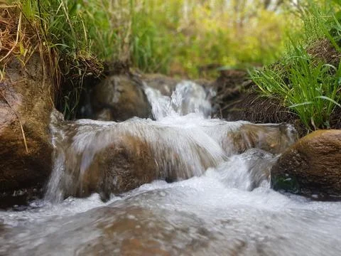 The water source flows down the rocks into the river Stock Photos