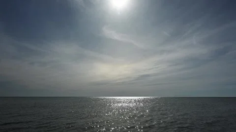 Water sparkling in a large lake under a blue sky filled with wispy clouds.  Stock Footage 274503330