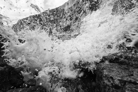 Water splash at the beach in Greece. Dramatic artistic filter applied. Black  Stock Photos