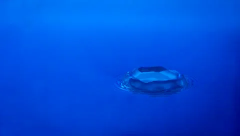 Water splash on blue background Stock Photos