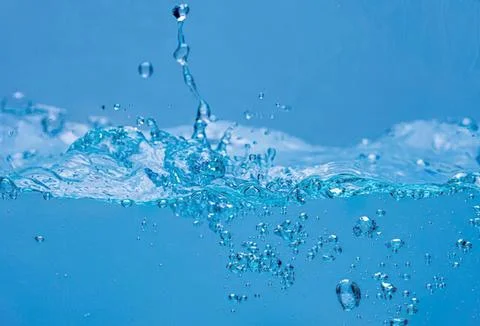 Water splash with bubbles in blue water surface Stock-Fotos