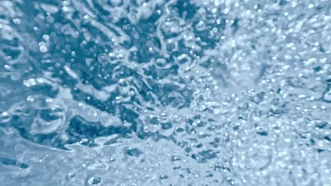Water splash creating dynamic surface ripples in macro view Stock Footage 316899616
