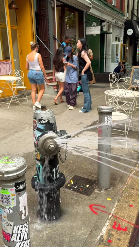Water splash from Fire Hydrant in front of Cafe at East Village in NYC Stock Footage 281082857
