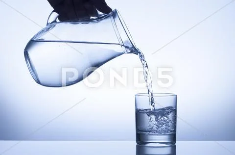 Water splash from a pitcher into a glass Stock Photos