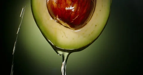 Water splash running down organic avocado. Close up of nutritious fresh juicy Stock Footage 154871290