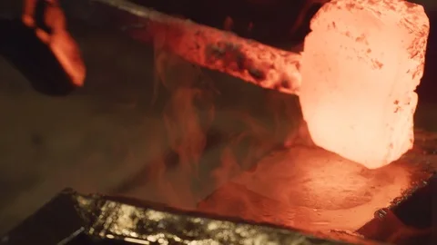Water is splashed on the anvil before glowing ingot is hammered Stock Footage 125413139