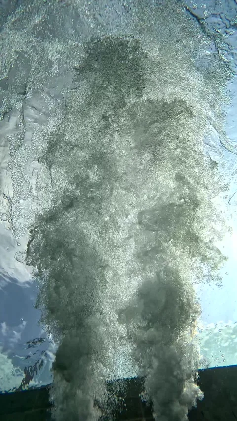 Water splashes and bubbles rise up from the pool surface at sunny midday Stock Footage 332936124