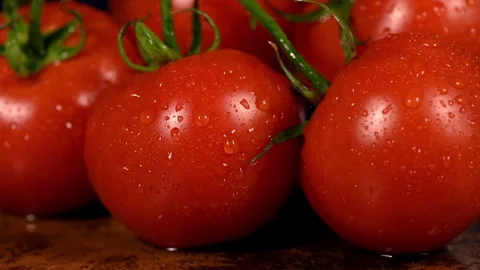 Water splashes fall on a fresh red ripe tomato on a rusty ginger table Stock Footage 247911778