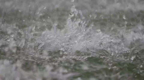 Water splashes on pond surface when rain shooting high speed camera Stock Footage 55735921