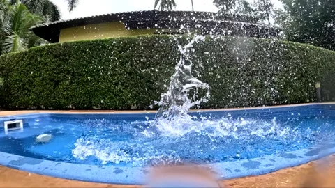 Water splashes from pool activity during sunny afternoon Stock Footage 325620484