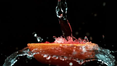 Water splashes on red grapefruit in slow motion against black background Stock Footage 327573746