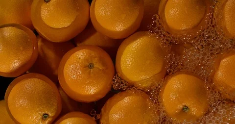 Water splashes on ripe oranges, slow motion macro shot Video stock 96545376