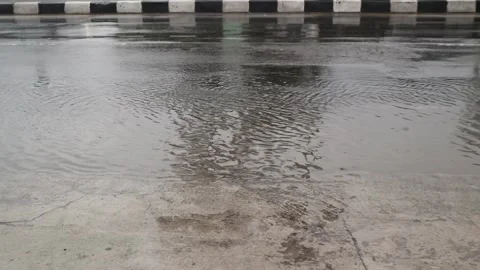Water splashes on the road from the wheels of vehicles Stock Footage 296145197