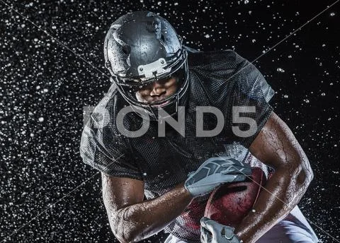 Water splashing on black football player Stock Photos