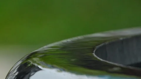 Water Splashing onto Glossy Black Ceramic Bowl Rim in Green Garden Vídeos de archivo 337410126