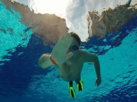 Water sports. Swimmer diver male dives in sunny pool with clear water Stock Footage