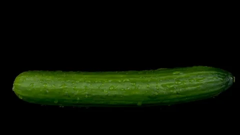 Water is sprayed on a cucumber. On a black isolated background. Slow motion Stock Footage 116811952