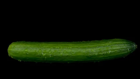Water is sprayed on a cucumber. On a black isolated background. Slow motion Stock Footage 116812596