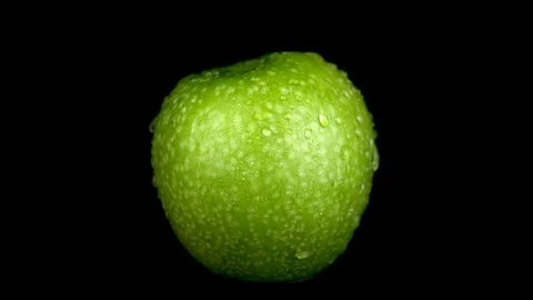 Water is sprayed on a green apple. On a black isolated background. Slow motion Stock Footage 116813018