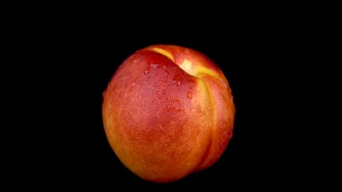 Water is sprayed on a peach. On a black isolated background. Slow motion Stock Footage 116813867