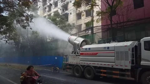Water spraying car ejecting water to the demolition house to prevent dust Stock Footage 83683454