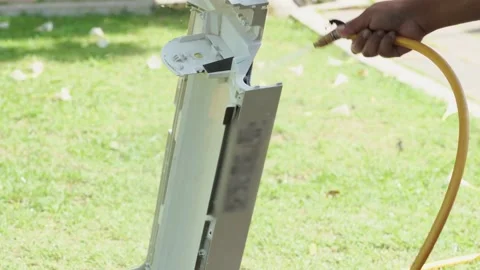 Water spraying cleaning contaminated and dirty air conditioner condenser Stock Footage 130892953